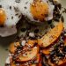 Delicious breakfast plate featuring avocado toast with fried eggs and persimmons, topped with seeds for a healthy start.